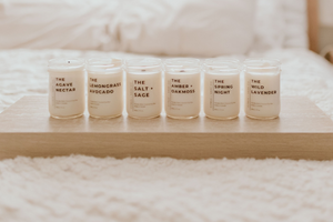 6 candles on a wooden platform on a bed