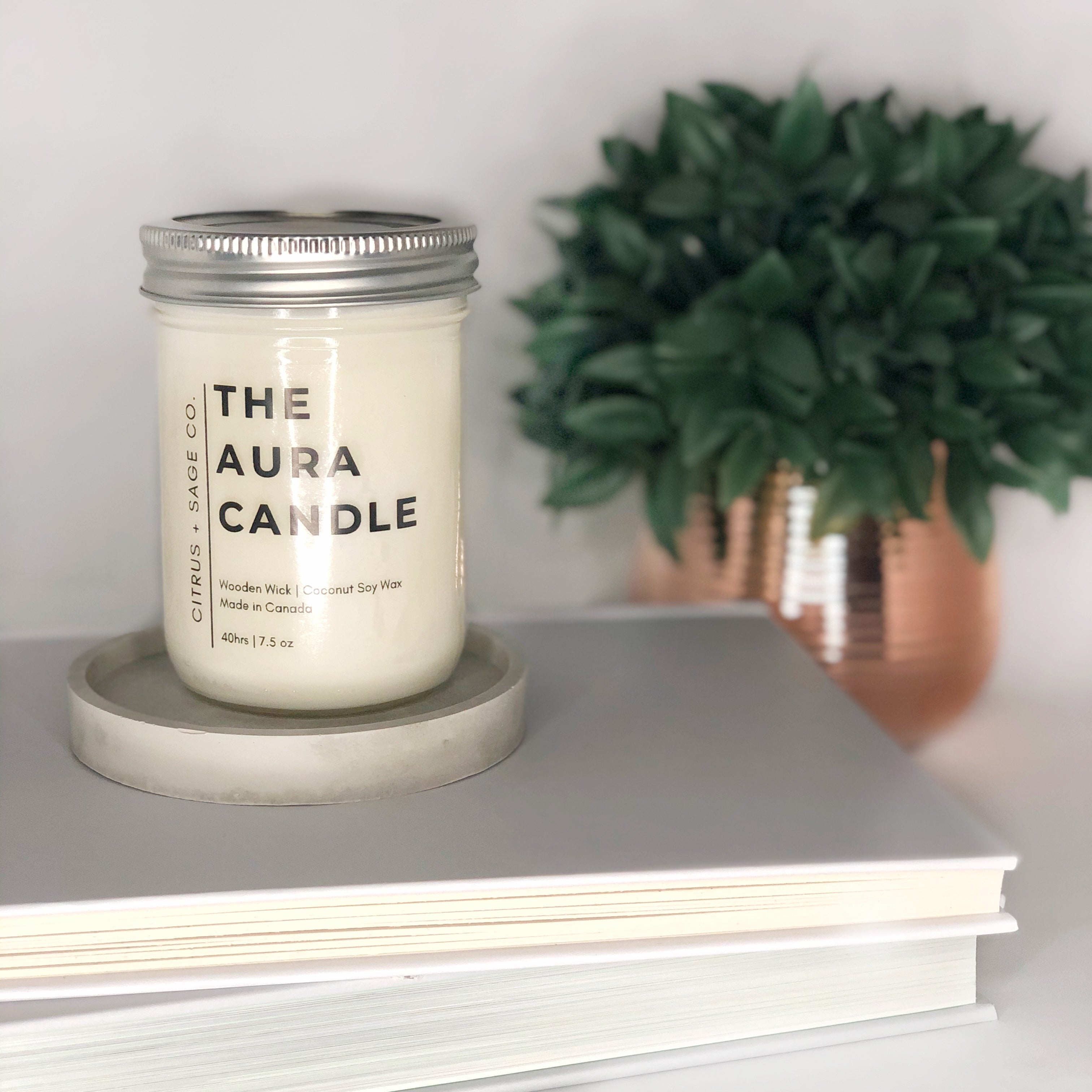 Coconut soy candle in mason jar with minimalist label on book stack