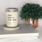 Load image into Gallery viewer, Coconut soy candle in mason jar with minimalist label on book stack
