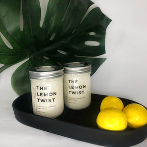 2 coconut soy candles with lemons on black dish