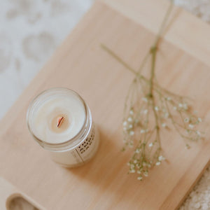 lit candle on wooden tray