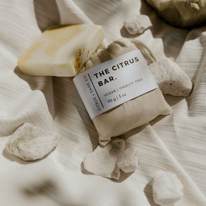 bar soap in cotton bag with orange and white bar soap resting on top