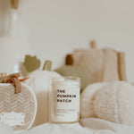 Load image into Gallery viewer, candle with light coloured pumpkins in background
