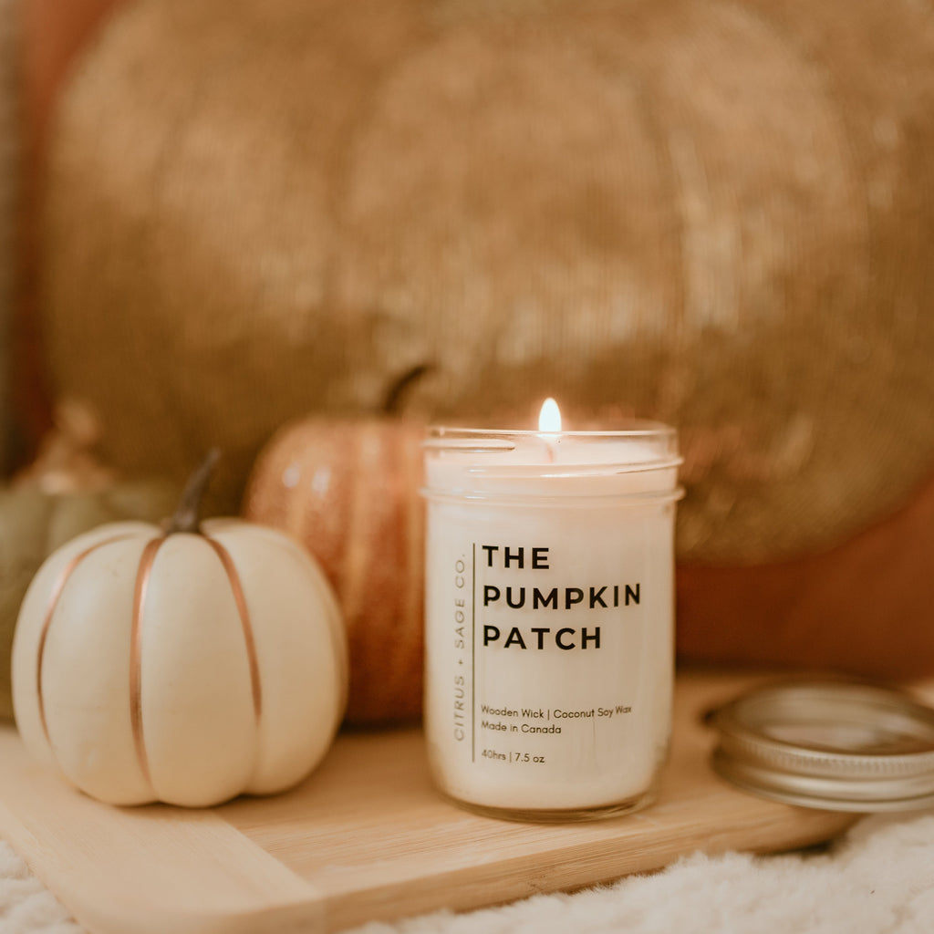 candle with light coloured pumpkins in background